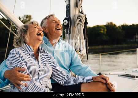 Cheerful couple laughing while spending leisure time in sailboat Stock Photo
