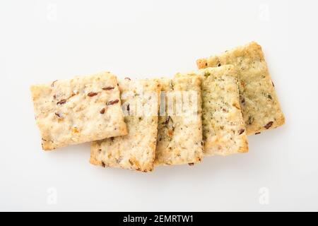 Stack of grain salty crackers with bran and flax seeds on white background. Top view. Stock Photo