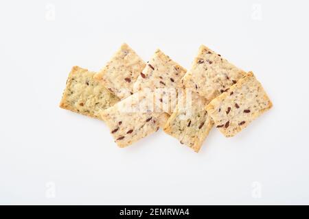 Stack of grain salty crackers with bran and flax seeds on white background. Top view. Stock Photo