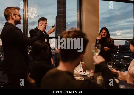 Female and male coworkers toasting while celebrating in office during party Stock Photo