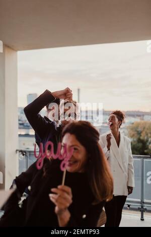 Cheerful male and female colleagues having fun while using props during company party Stock Photo