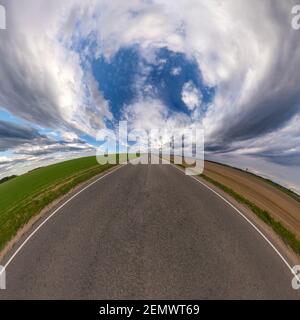 hemisphere of the planet on an asphalt road stretching beyond the horizon with blue sky and beautiful clouds. Spherical abstract aerial view. Curvatur Stock Photo