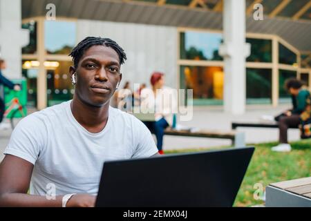 Portrait of African male student with laptop in university Stock Photo