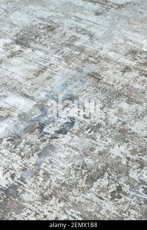 Background from a stylish carpet in neutral gray-beige-blue tones with fading and artificial antiquity effect. Concept details of a fashionable interi Stock Photo