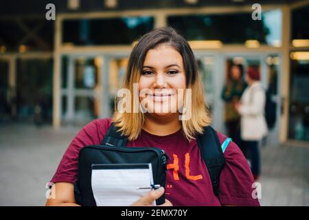 Portrait of smiling female student in college campus Stock Photo