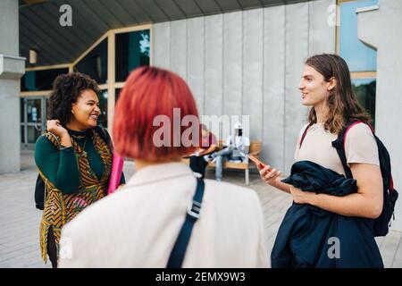 College students talking while standing in classroom Stock Photo - Alamy