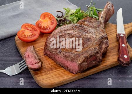 Grilled ribeye tomahawk beef steak with salad Stock Photo