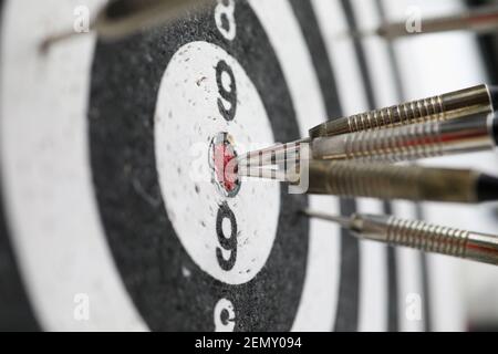 Metal darts sticking out in a dartboard target Stock Photo