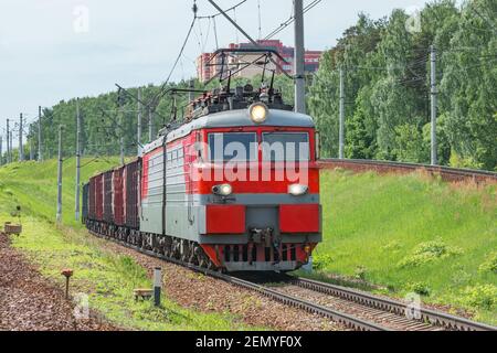 Long freight train approaches to the station. Stock Photo