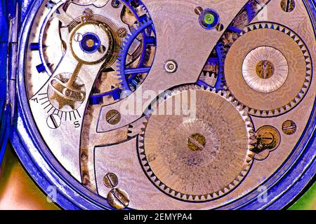Pocket watch clockwork workings open case in blue and pink Stock Photo