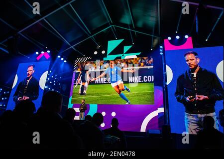 Martin seen speaking while Some images of Nike are projected the conference.