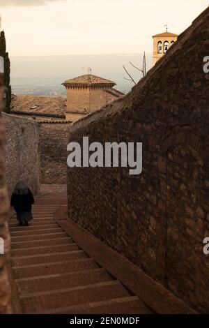 n the morning a nun goes to the basilica of San Francesco - Assisi - Italy Stock Photo