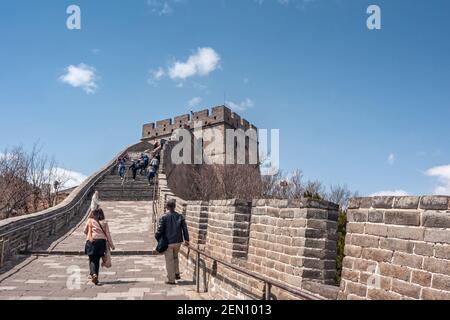 Beijing, China - April 28, 2010: Great Wall of China. Brown stone climbing section with visitors on steps under blue cloudscape. Stock Photo