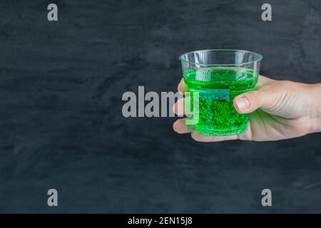 Green drink in the hand with water bubbles inside Stock Photo
