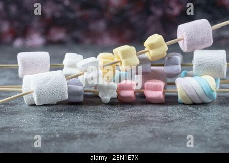 Colorful marshmallows on the wooden sticks to be grilled Stock Photo
