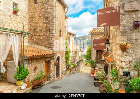 A narrow alley of cafes and shops in the hillside walled medieval village of Gourdon, France. Stock Photo