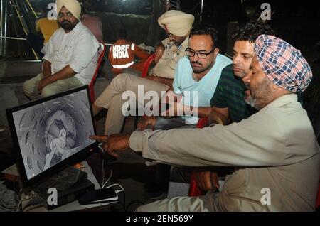 SANGRUR, INDIA - JUNE 10: Fatehveer Singh's grandfather Rohi Singh watches the live footage of his grandson's rescue operation on a screen early in the morning at 2:15 am, at Bhagwanpur village, on June 10, 2019 in Sangrur, India. Fatehvir Singh, a two-year-old boy remained stuck in a 150-foot-deep borewell in Punjab's Sangrur district, amid mounting anger over the delay in retrieving him even after over 100 hours since he fell into it. He fell into fell into the unused seven-inch wide borewell in a field around 4 pm on Thursday.(Photo by Bharat Bhushan/Hindustan Times/Sipa USA)