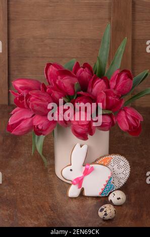 Pink tulips and easter bunny cookie on wooden background. Spring or easter concept Stock Photo