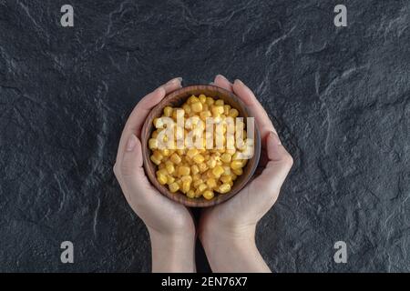 Female holding bowl of corn seeds with hand Stock Photo