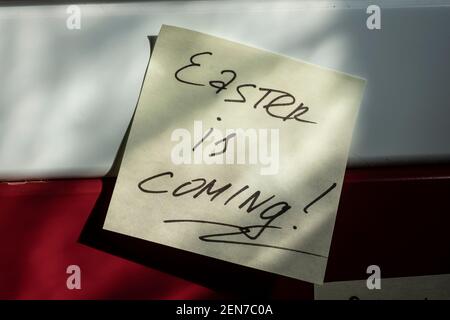 easter is coming - an inscription on an orange sticker, a greeting and a reminder of the main holiday of spring. Stock Photo