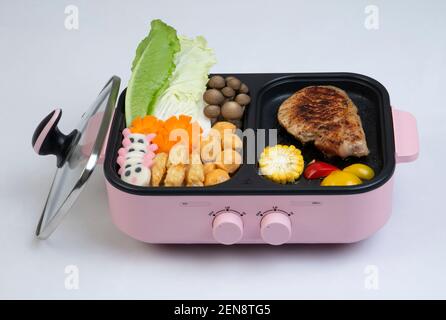 Electric grill stove with food and cover isolated on white background Stock Photo