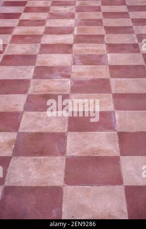 Terracotta floor old tiles background, texture. Retro, vintage tiled flooring, red, pink white color. Ceramic tiles chessboard style floor, perspectiv Stock Photo