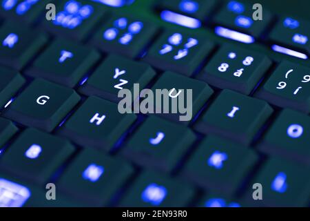 Closeup of laptop or desktop computer keyboard illumination, blue backlit keyboard Stock Photo
