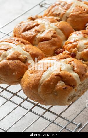 Freshly baked hot cross buns on a metal cooling rack.  Easter food concept Stock Photo