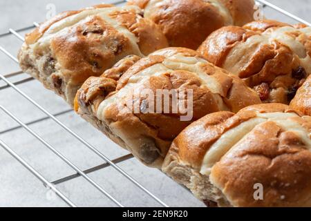 Freshly baked hot cross buns on a metal cooling rack.  Easter food concept Stock Photo