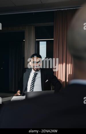 Smiling businessman looking at male colleague in board room during meeting Stock Photo