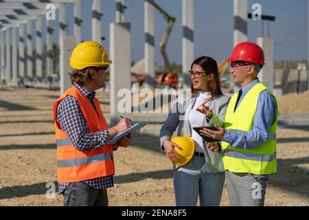 Project Management and Field Crew Meeting on Construction Site. Business, Building, Teamwork and People Concept. Stock Photo