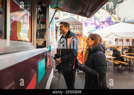 Happy couple standing by counter at food truck Stock Photo