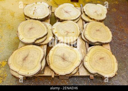 Shot from above on thinly cut wooden round pieces for decoration stacked on a pallet. Stock Photo