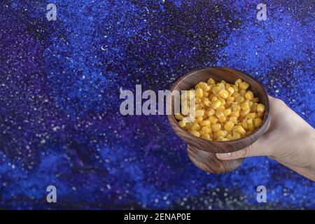 Female hand holding Bowl Canned sweet corns Stock Photo