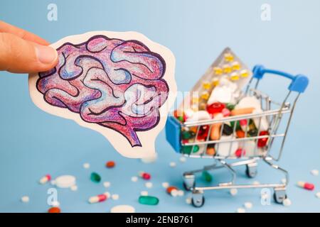 Treatment and prevention brain diseases with variety of pills: antibiotics, vitamins, painkillers, antidepressants. drawing of human brain in hand aga Stock Photo