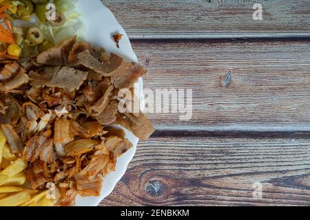 Doner kebab. Grilled beef meat with space for text on wooden background. Stock Photo