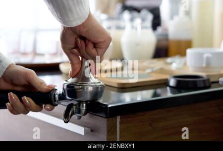 Barista making fresh espresso coffee. The shopkeeper preparing coffee on counter. Stock Photo