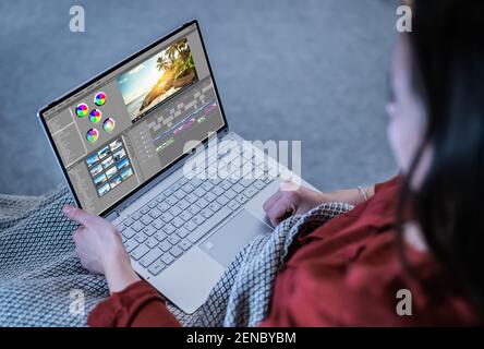 Young Female Editor Editing Video On Computer At Night Stock Photo