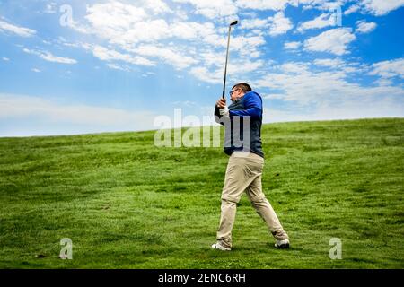 Golfer trying to make the perfect shot with a golf club Stock Photo