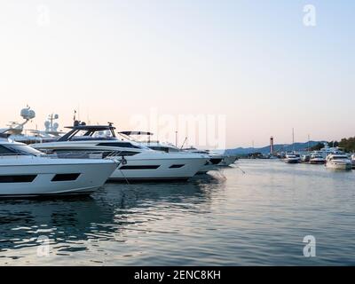 The yachts are moored in the calm sea and the silhouette of the mountains can be seen in distance Stock Photo