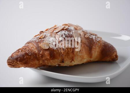 Traditional French breakfast croissant with almonds on white background Stock Photo