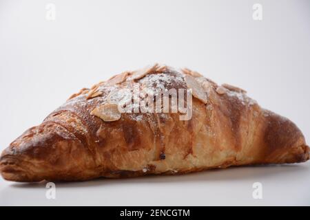 Traditional French breakfast croissant with almonds on white background Stock Photo