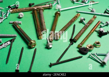 Photo of different types of screws over green background. Stock Photo