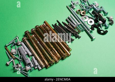 Photo of different types of screws over green background. Stock Photo