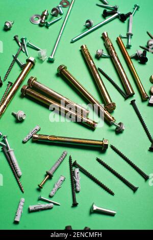 Photo of different types of screws over green background. Stock Photo