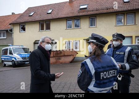 Thuringia, Ballstädt, 26 February 2021: Georg Maier (l, SPD), Thuringia's interior minister, talks to police officers in front of a house that can be classified as belonging to the right-wing scene. With a large-scale raid, police in several federal states have taken action against a neo-Nazi network. The searches in Thuringia, Saxony-Anhalt, and Hesse involved suspected large-scale drug trafficking and money laundering, according to the Thuringia State Criminal Police Office (TLKA) on Friday morning. Credit: dpa picture alliance/Alamy Live News Stock Photo