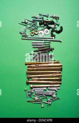 Photo of different types of screws over green background. Stock Photo