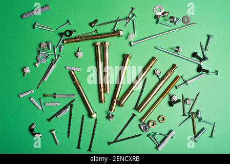 Photo of different types of screws over green background. Stock Photo