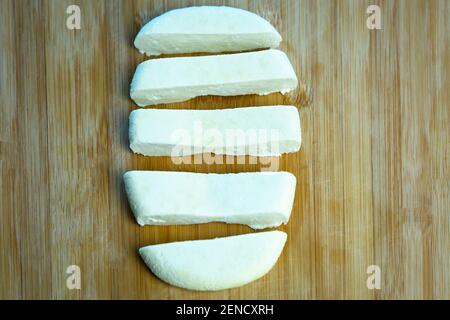 Homemade paneer cheese made from fresh milk and lemon juice, diced on a wooden chopping board background. Horizontal orientation. Close up shot Stock Photo