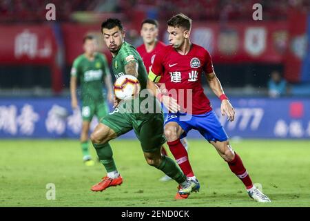 Brazilian football player Olivio da Rosa, also known as Ivo, right, of Henan Jianye passes the ball against English football player Nico Yennaris, known in China as Li Ke, of Beijing Sinobo Guoan in their 20th round match during the 2019 Chinese Football Association Super League (CSL) in Zhengzhou city, central China's Henan province, 27 July 2019. Henan Jianye defeated Beijing Sinobo Guoan 1-0. (Photo by Stringer - Imaginechina/Sipa USA)